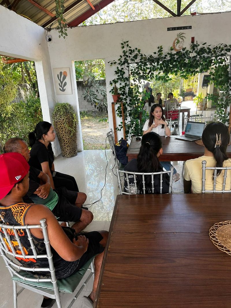 Mary Joice leading a small, informal discussion at a garden café table